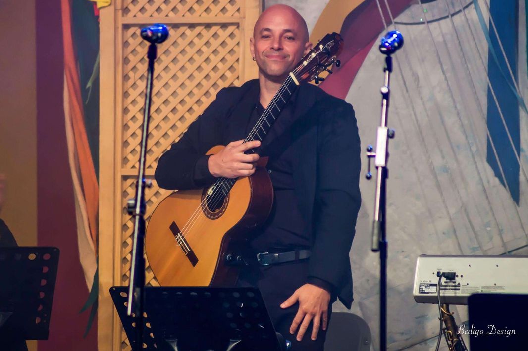 Marco del Castillo posando de pie con una guitarra